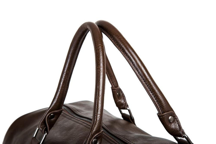 Zijkant van de robuuste zwarte leren duffeltas, perfect voor mannen die een stijlvolle reistas zoeken.