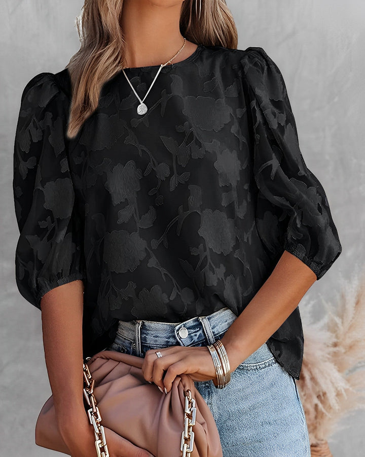 Dames top met elegante bloemstructuur en speelse bubbelmouwen, perfect voor lente en zomer.