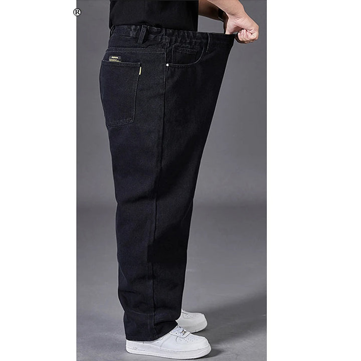 Man beweegt in comfortabele grote maten jeans met wijde pijpen. Ruime pasvorm voor heren spijkerbroek.