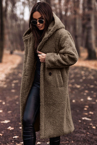Damesjas gedragen: lange teddy winterjas met capuchon, elegante en warme bovenkleding voor de koude dagen.