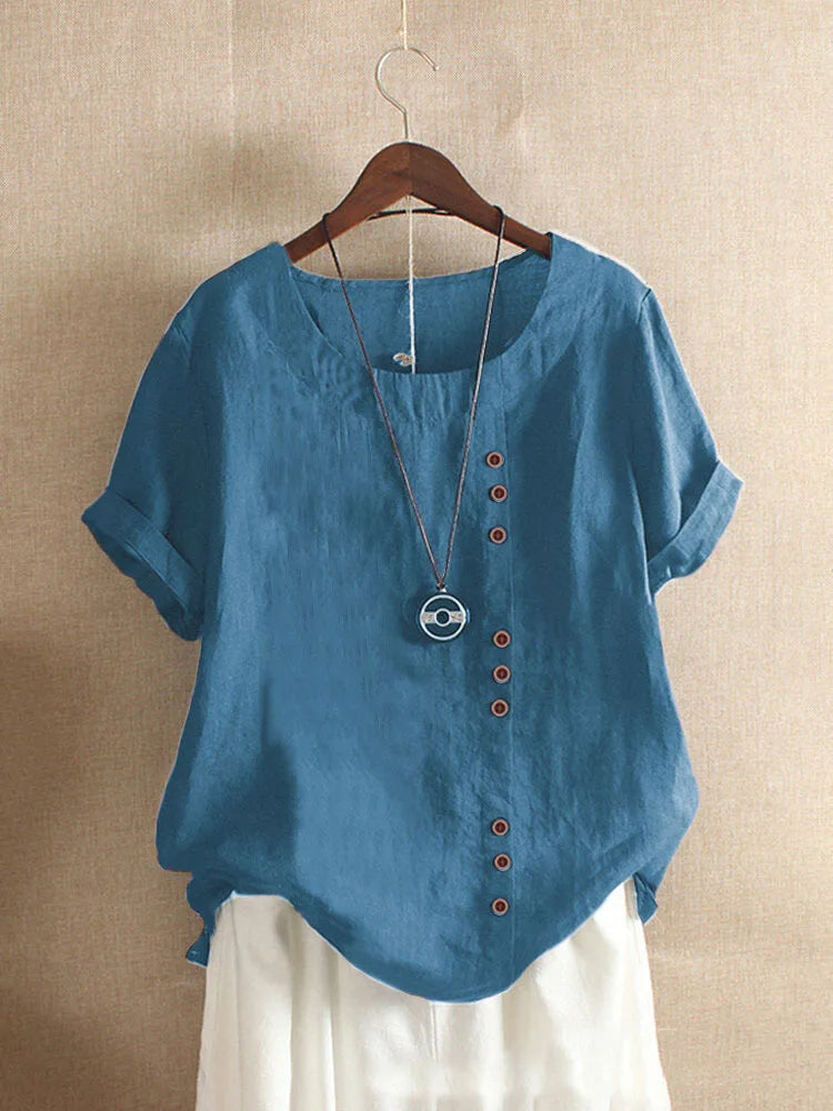 Luchtige losse pasvorm damesblouse met korte mouwen, knoopdetails en Peter Pan kraag. Comfort voor warme zomerdagen.