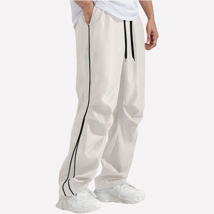 Detailopname van de zachte stretch polyester stof van de heren jogger broek met nauwkeurig gestikte zijstrepen.