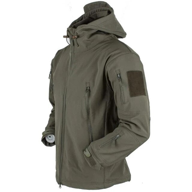 Man draagt robuuste militaire winterjas met capuchon tijdens een outdoor avontuur in de natuur.