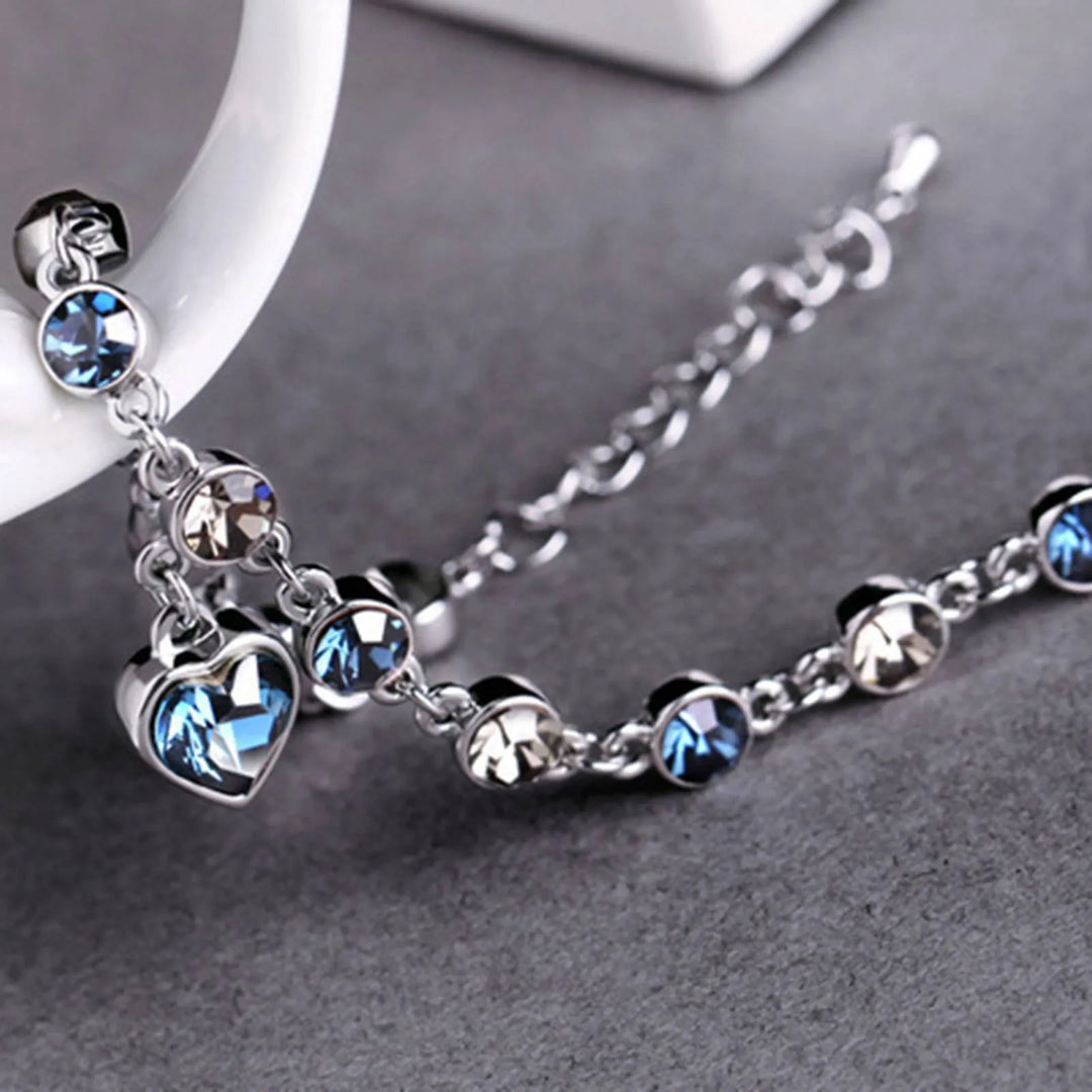 Glinsterende damesarmband van kristal en zirkonia met een blauwe hartbedel. Elegant verstelbaar sieraad.