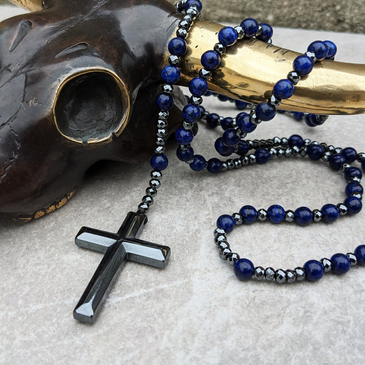 Close-up van mannen rozenkrans ketting: tijgeroog, lapis lazuli edelstenen en gedetailleerd kruis.