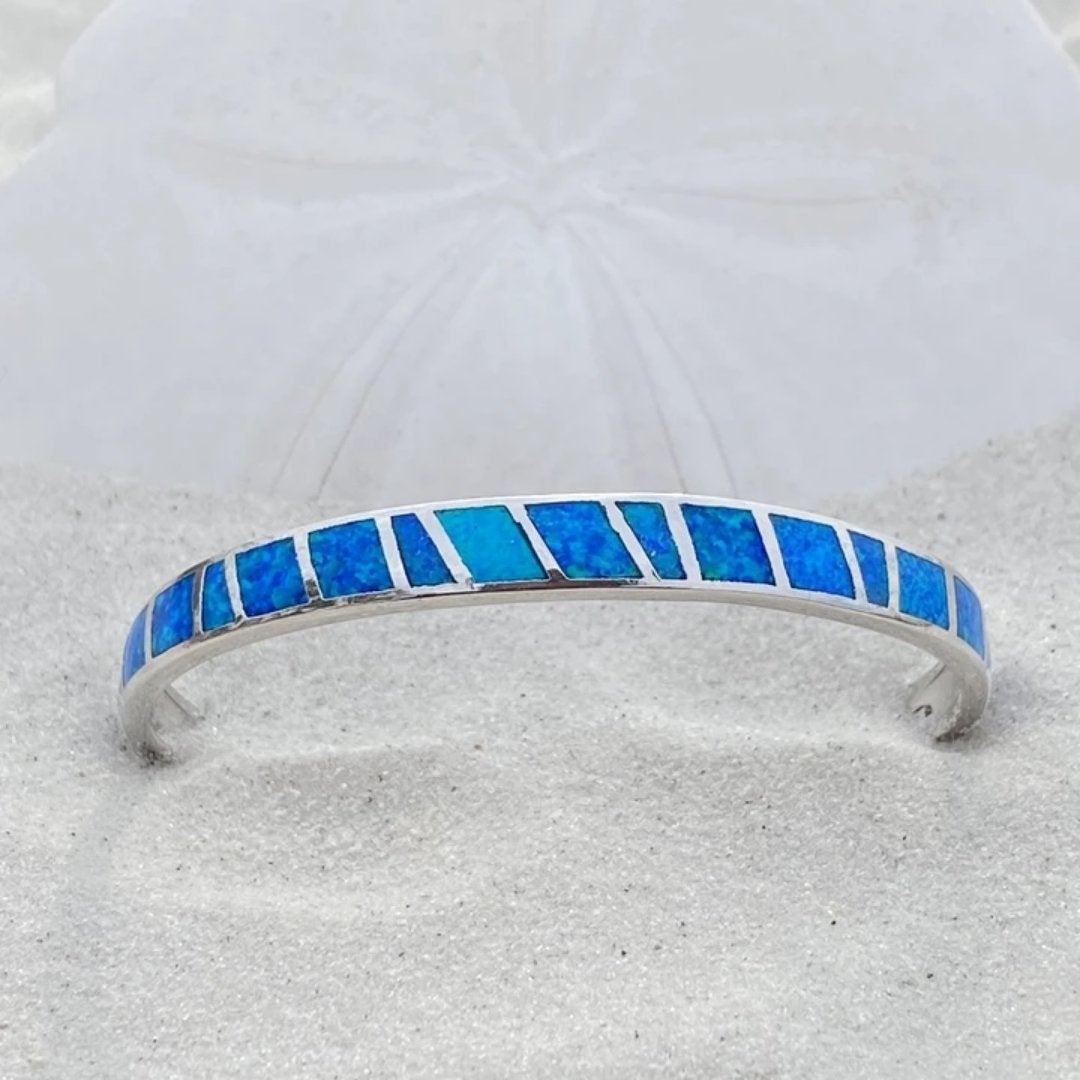 Close-up van Isola zilveren damesarmband met diepblauwe opaal. Tijdloos sieraad, oceaan-geïnspireerd.