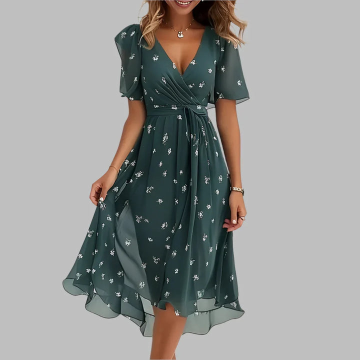 Lente/zomer damesjurk: geplooide midi-jurk met bloemenprint, ruches en pofmouwen voor een casual chique look.
