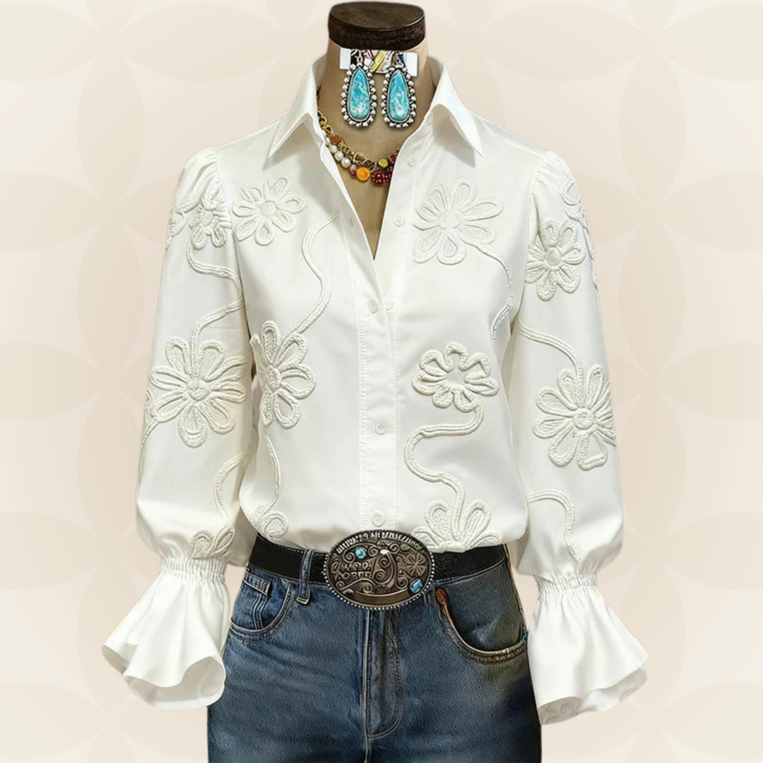 Elegante witte damesblouse met geborduurde details en stijlvolle rufflemouwen, perfect voor een chique look.