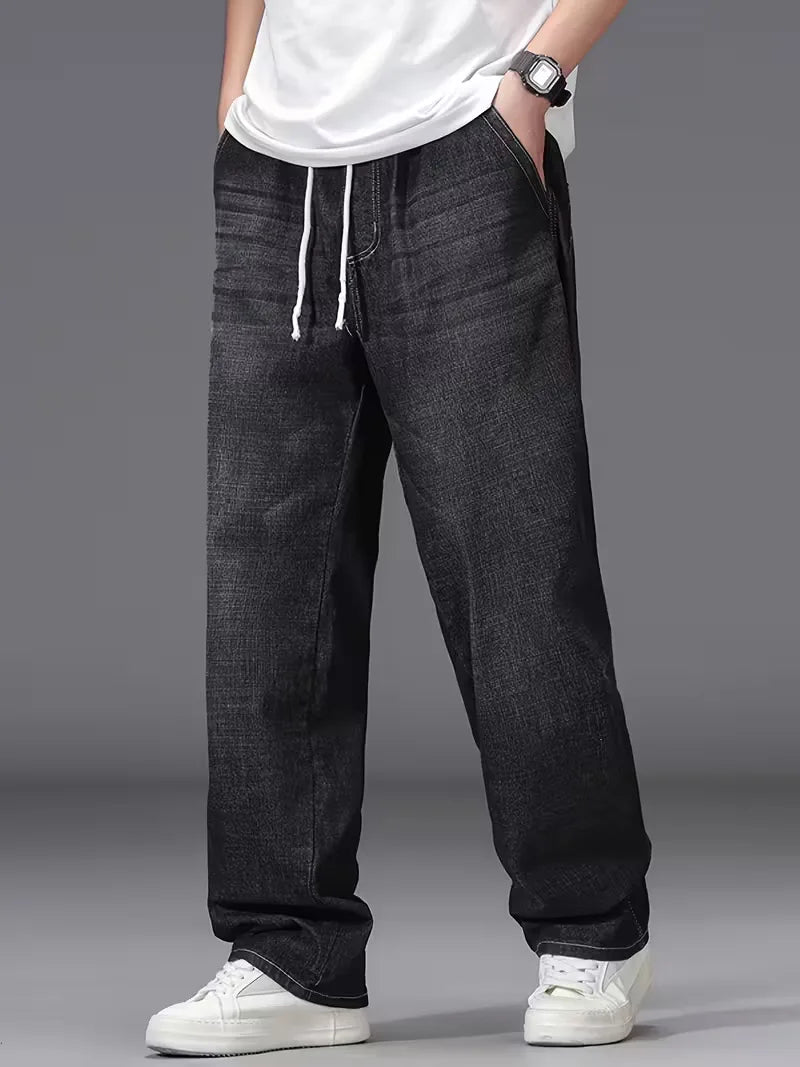 Vooraanzicht van casual heren spijkerbroek met losse pasvorm, elastische taille en ruime zakken.