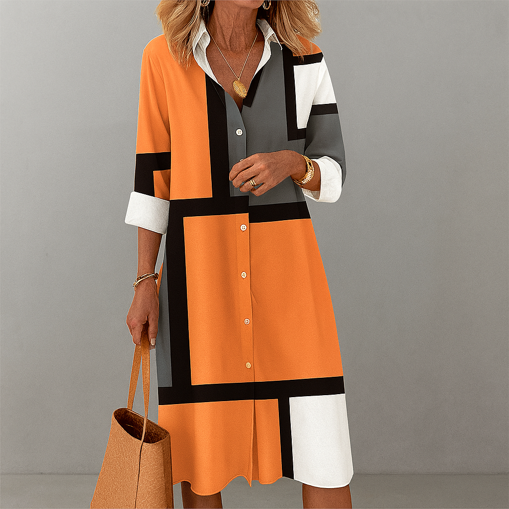 Dames overhemdjurk met levendig geometrisch patroon in oranje, blauw, grijs en roze. Modieus en comfortabel voor zomer/lente.