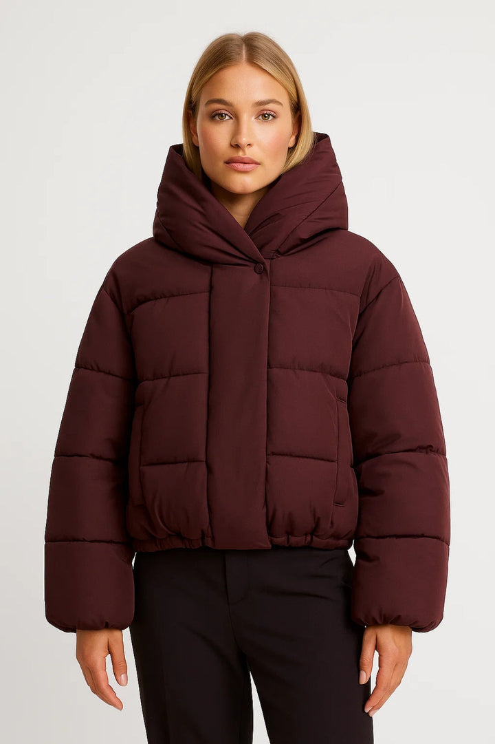 Casual zwarte dames winterjas; een korte gewatteerde puffer met ruime capuchon, perfect voor de stad.