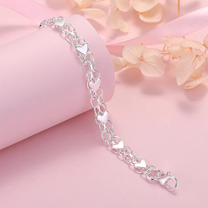 Verzilverde schakelarmband voor dames met fijne hartjes, een elegant en klassiek mode-sieraad.