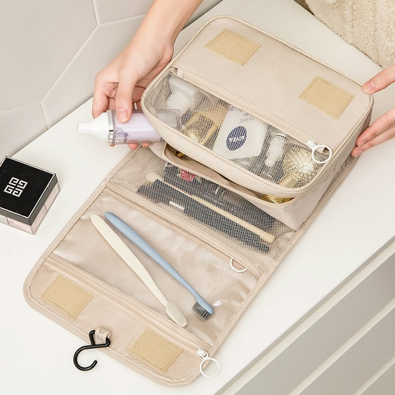 Opengeklapte dames make-up tas met meerdere compartimenten voor georganiseerd reizen.