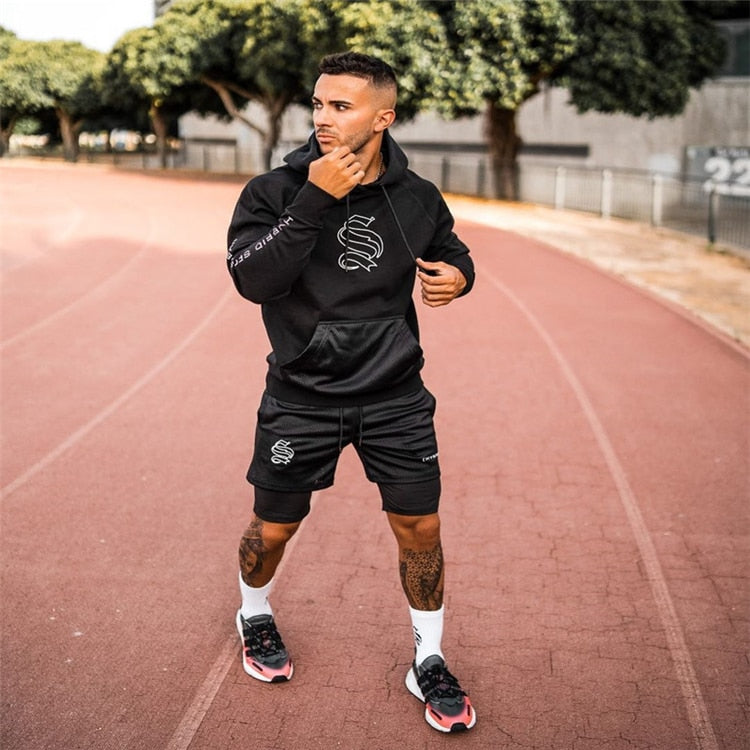 Man traint in gym met heren 2-in-1 compressie shorts, focust op kracht en flexibiliteit.