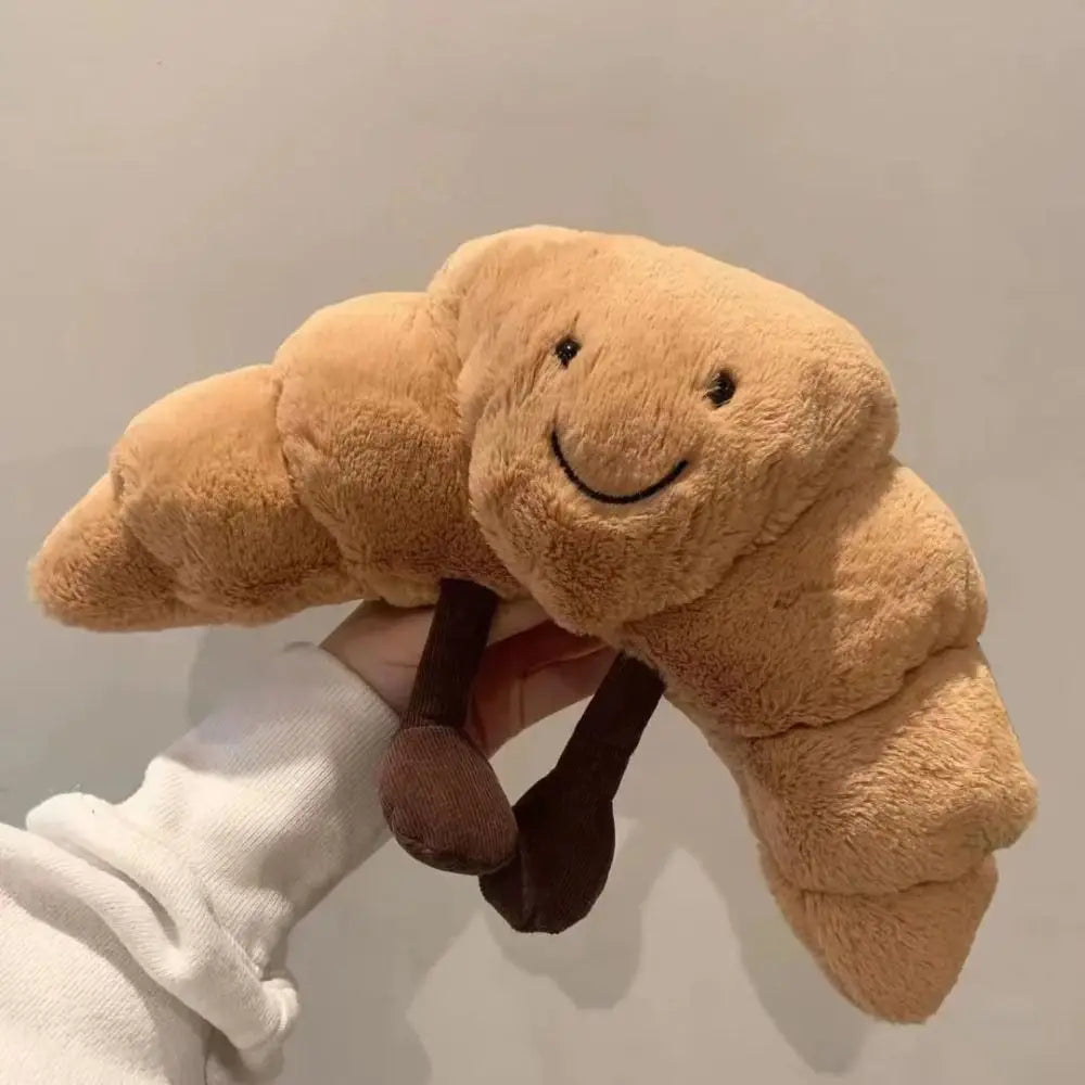 Uniek pluche croissant broodkussen, realistisch design, perfect als knuffel en originele decoratie.