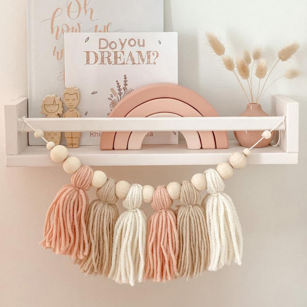 Houten babyslinger met neutrale kraaltjes voor rustgevende babykamer decoratie.