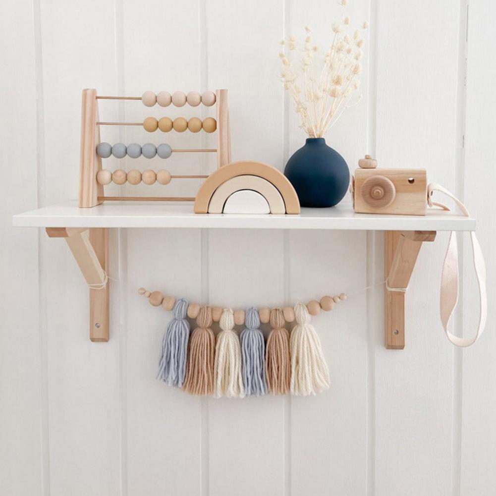 Babykamer decoratie: houten babyslinger met neutrale tinten en kraaltjes.