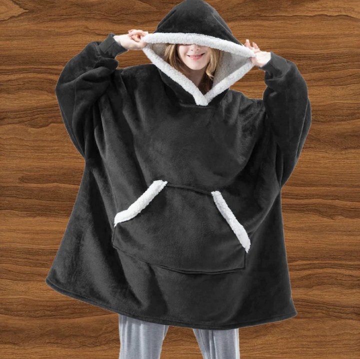 Ontspannen moment in de uniseks thermische fleece hoodie Noah, perfect voor relaxen thuis of casual buitenactiviteiten.