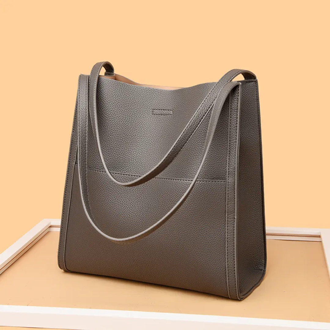 Hoogwaardige leren handtas voor dames, ruim hoofdcompartiment, stevige handvatten, stijlvol design.