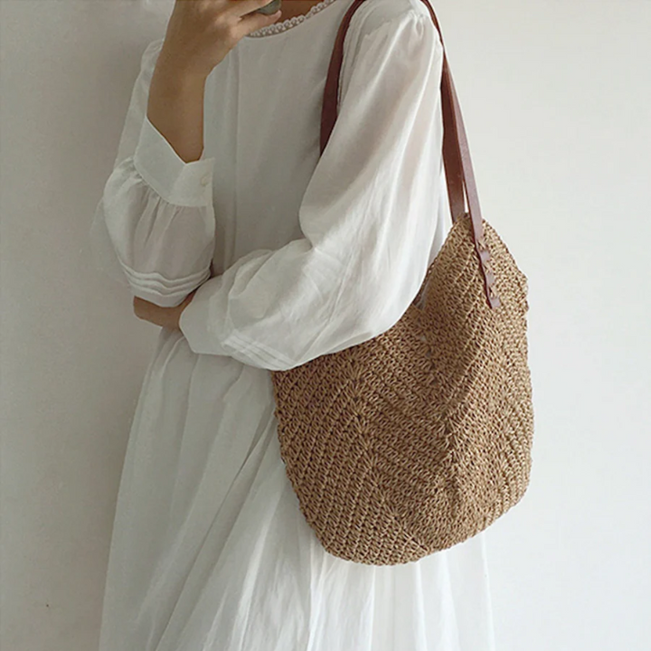 Ruime dames schoudertas met trendy geweven look, beschikbaar in wit en bruin. Perfect voor modebewuste vrouwen.