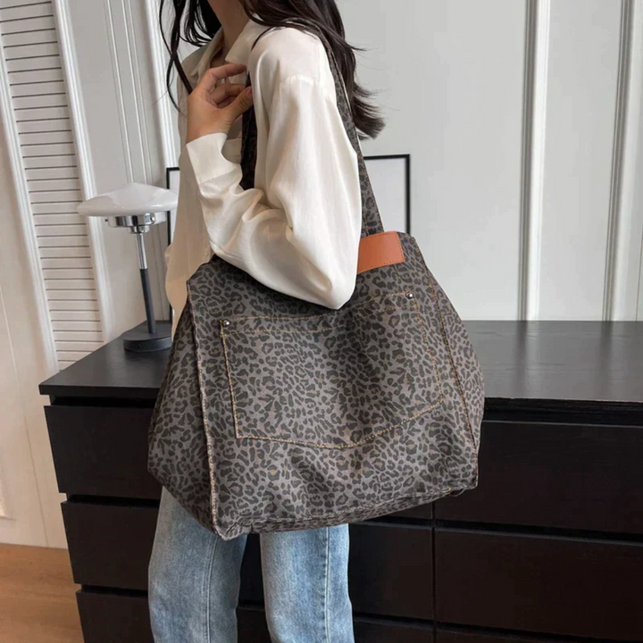 Zijkant van een trendy dames tas met levendige luipaardprint, een must-have mode accessoire.