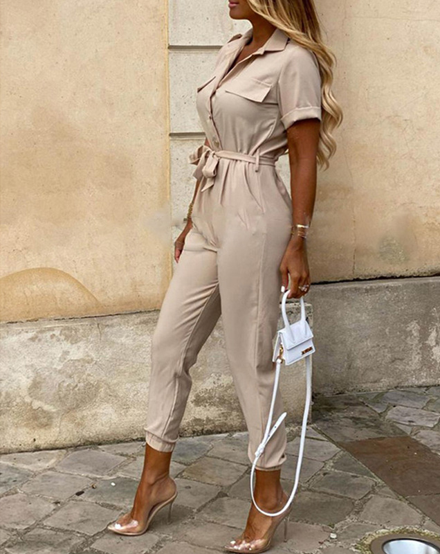 Detailopname van de verstelbare ceintuur op de modieuze dames jumpsuit. Benadrukt de taille voor een elegante look.