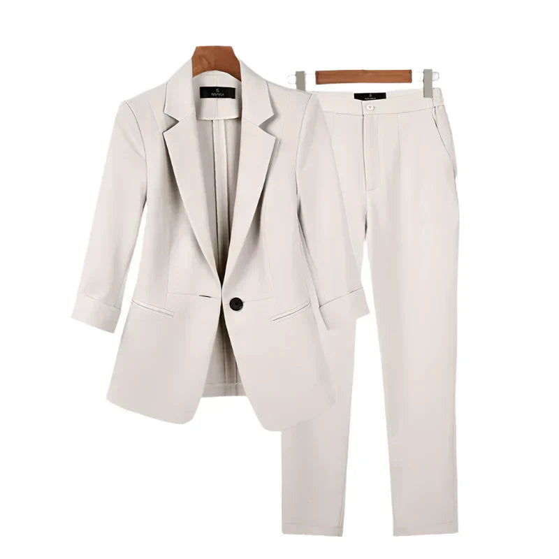Model draagt elegante tweedelige blazerset, zakelijk kostuum voor dames. Perfect voor een stijlvolle en formele look.