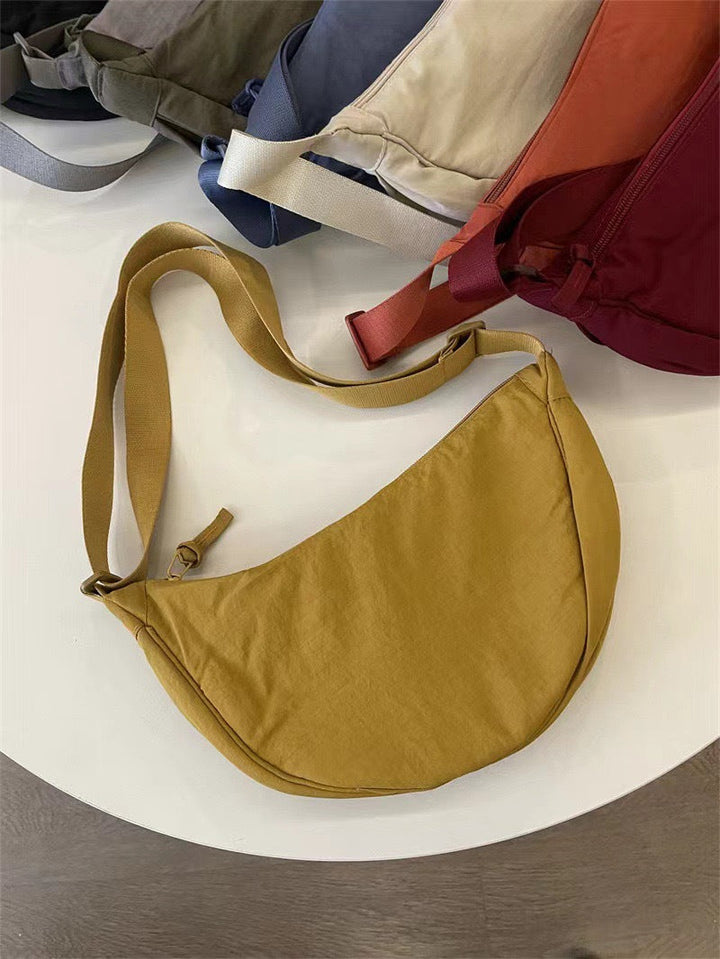 Dames accessoire: gebogen schoudertas met verstelbare riem. Een elegante toevoeging aan elke look.