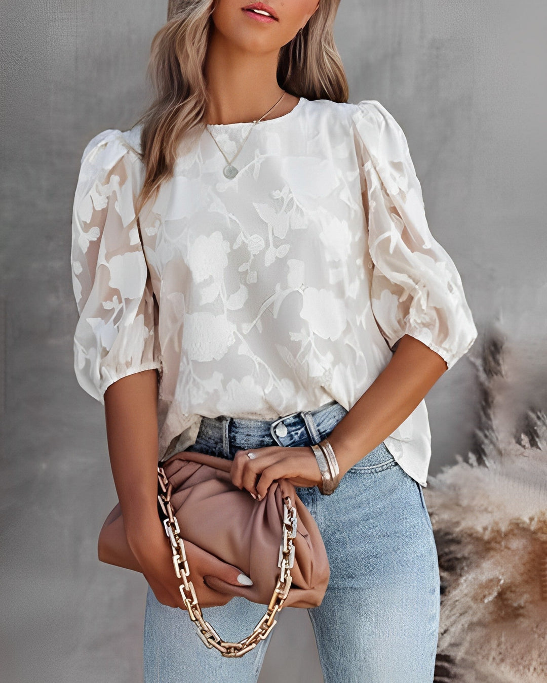 Dames top met elegante bloemstructuur en speelse bubbelmouwen. Stijlvolle en comfortabele zomerblouse.