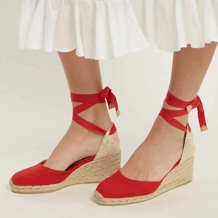 Close-up van de details: gevlochten zool en stijlvolle enkelbandjes van deze dames espadrilles sleehak.
