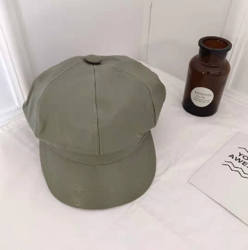 Zwarte kunstleren baret, een veelzijdig accessoire en tijdloos hoofdeksel.