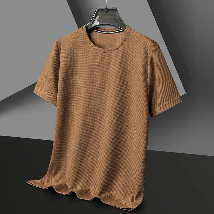 Detail van de wafelstructuur op een comfortabel heren T-shirt met ronde hals en korte mouwen. Focus op stof.
