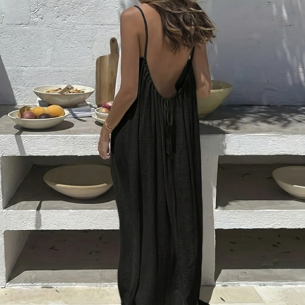 Model draagt een casual lange zomerjurk met open rug, perfect voor ontspannen dagen thuis.