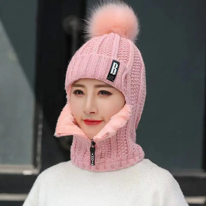 Vrouw draagt een comfortabele gebreide bivakmuts met pompon, ideaal voor winterse mode en warmte.