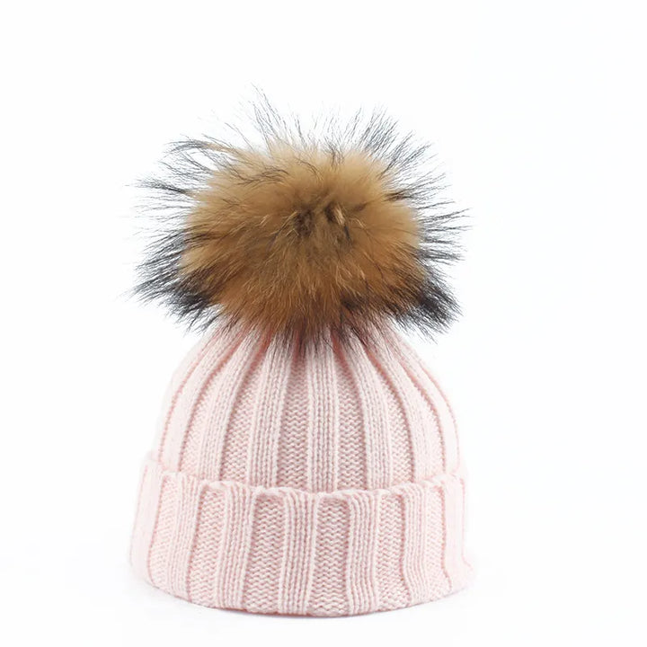 Vrouw draagt een warme, gebreide Felina dames wintermuts met zachte pompon. Een comfortabel mode accessoire.